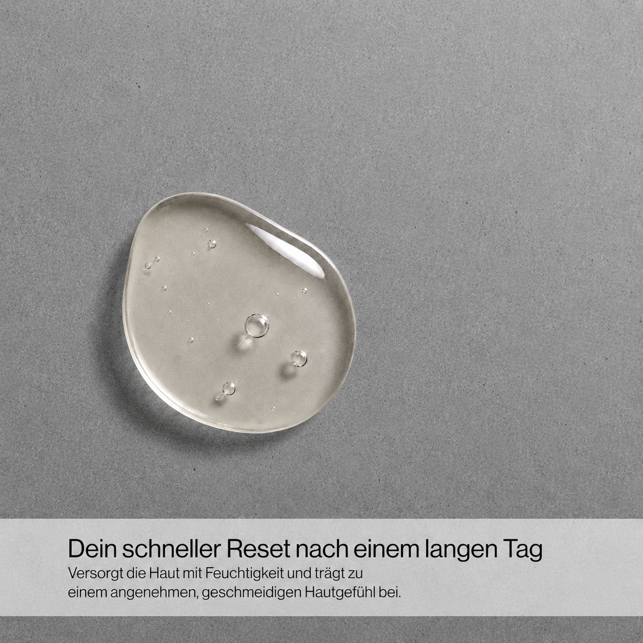Nahaufnahme eines transparenten Gelkleckses auf grauem Untergrund mit Text 'Dein schneller Reset nach einem langen Tag Für die Anwendung auf Haar, Körper und Gesicht geeignet'
