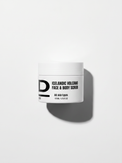 Weißer Tiegel mit schwarzer Aufschrift "ICELANDIC VOLCANO FACE & BODY SCRUB" und Schatten auf weißem Hintergrund