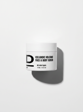 Weißer Tiegel mit schwarzer Aufschrift "ICELANDIC VOLCANO FACE & BODY SCRUB" und Schatten auf weißem Hintergrund