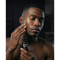 Mann trägt D MEN Softening Beard Oil auf sein Gesicht auf für eine gepflegte Bartpflege.