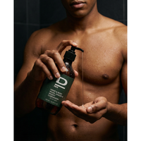 Mann mit D Männer Hand- & Körperwaschmittel mit Ingwer und Kardamom in der Dusche.