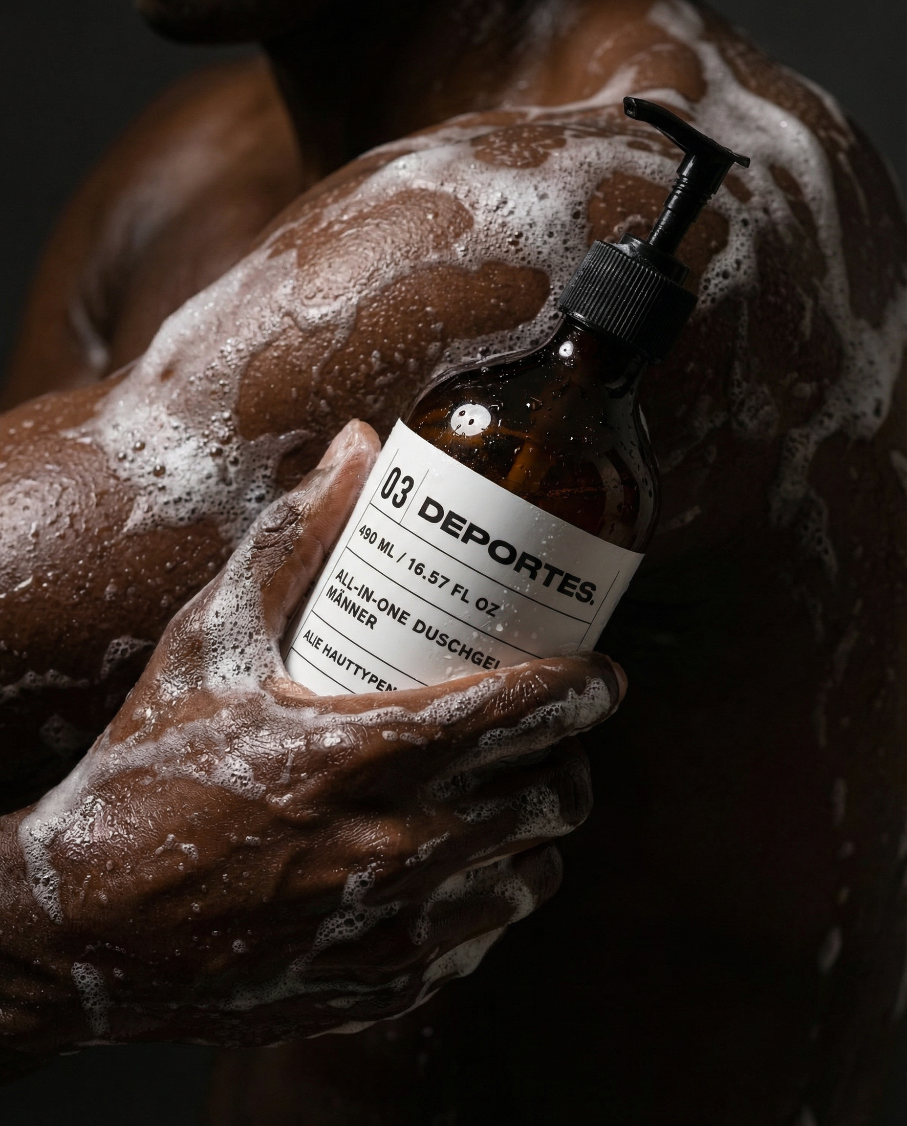 Nahaufnahme eines schaumigen Oberkörpers, der eine braune Flasche mit schwarzem Spender und weißem Etikett hält.