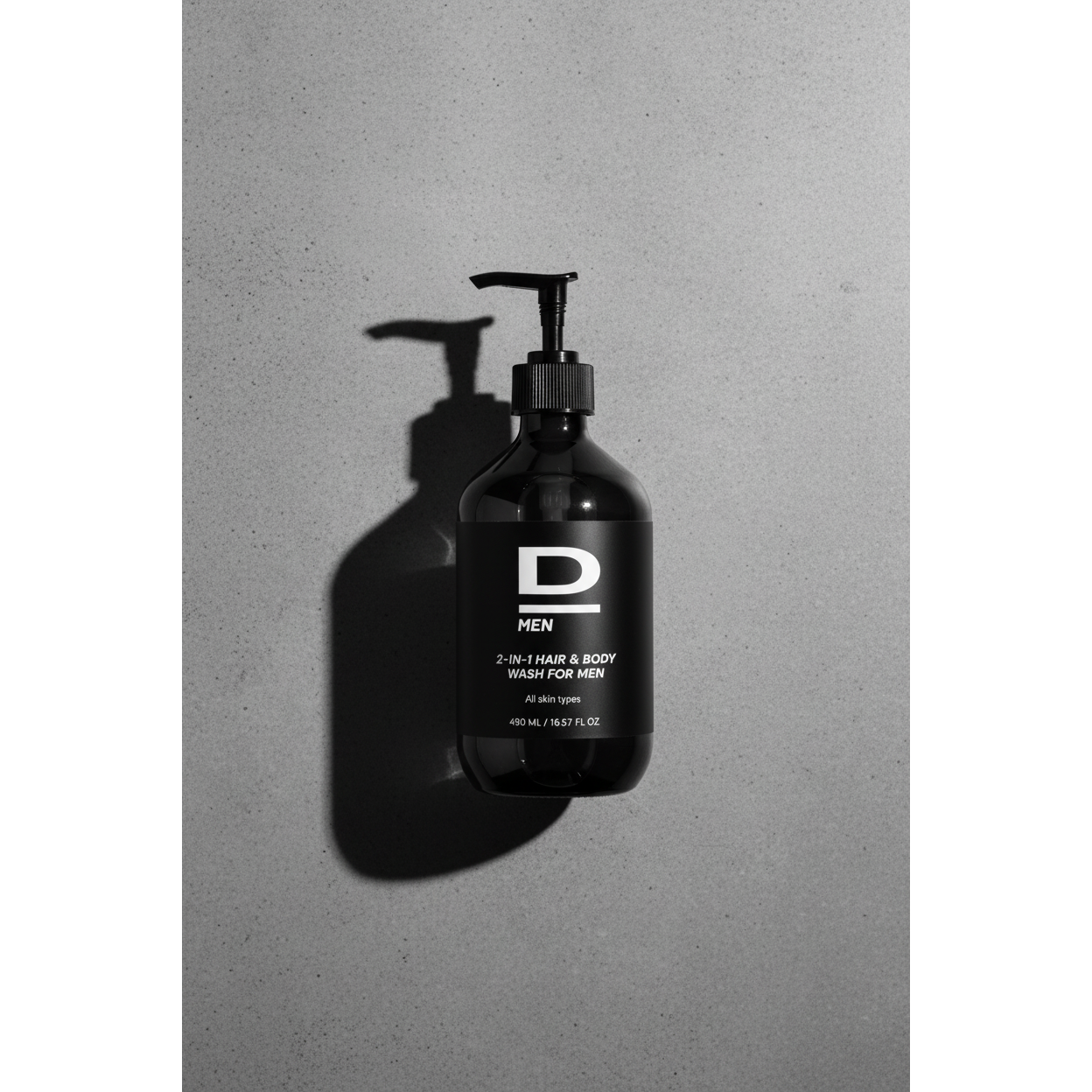 Schwarz-weiße Aufnahme einer Flasche mit Pumpverschluss und Aufschrift 'D MEN 2-IN-1 HAIR & BODY WASH FOR MEN All skin types 480 ML / 16.57 FL OZ'
