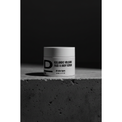 Face & Body Scrub nah. Rundes Kosmetikgefäß mit der Aufschrift 'ICELANDIC VOLCANO FACE & BODY SCRUB' auf rauer Betonoberfläche vor dunklem Hintergrund