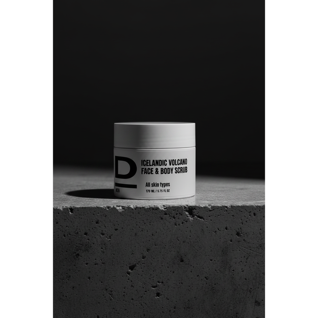 Face & Body Scrub nah. Rundes Kosmetikgefäß mit der Aufschrift 'ICELANDIC VOLCANO FACE & BODY SCRUB' auf rauer Betonoberfläche vor dunklem Hintergrund