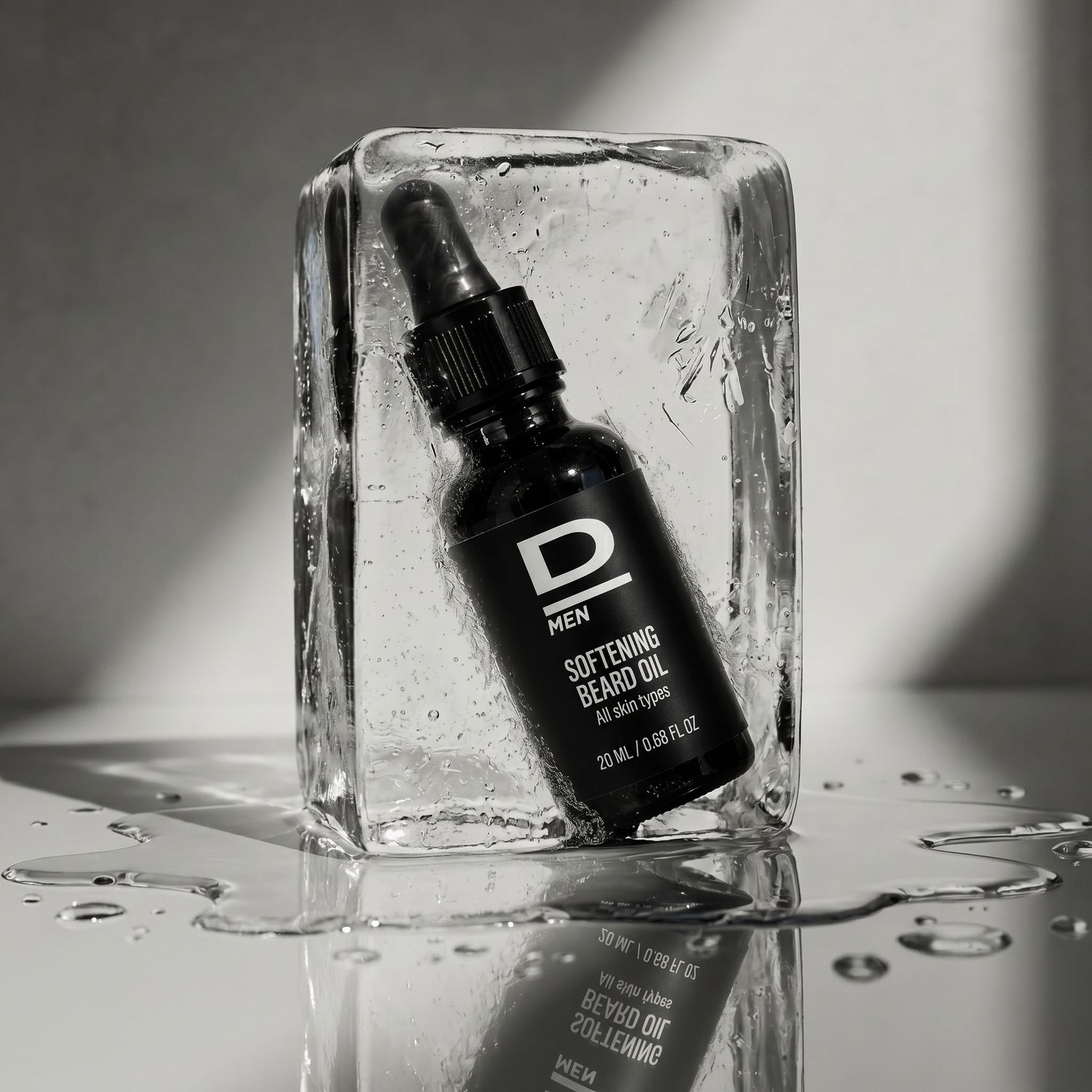 Flasche mit Tropfer für Bartöl steht in einem Eisblock auf reflektierender Oberfläche mit Wassertropfen