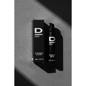 Aufrecht stehende schwarze Verpackung und Flasche mit weißer Aufschrift 'D MEN OIL-FREE ZINC FACE GEL FOR MEN 50 ML / 1.69 FL OZ' auf grauem Untergrund mit Schatten