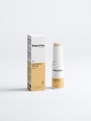 Weißer Verpackungskarton mit schwarzer Schrift, auf dem steht 'Deportes Sun Protection Stick ohne Tönung'. Neben dem Karton steht ein runder, weißer Sonnenschutzstick.