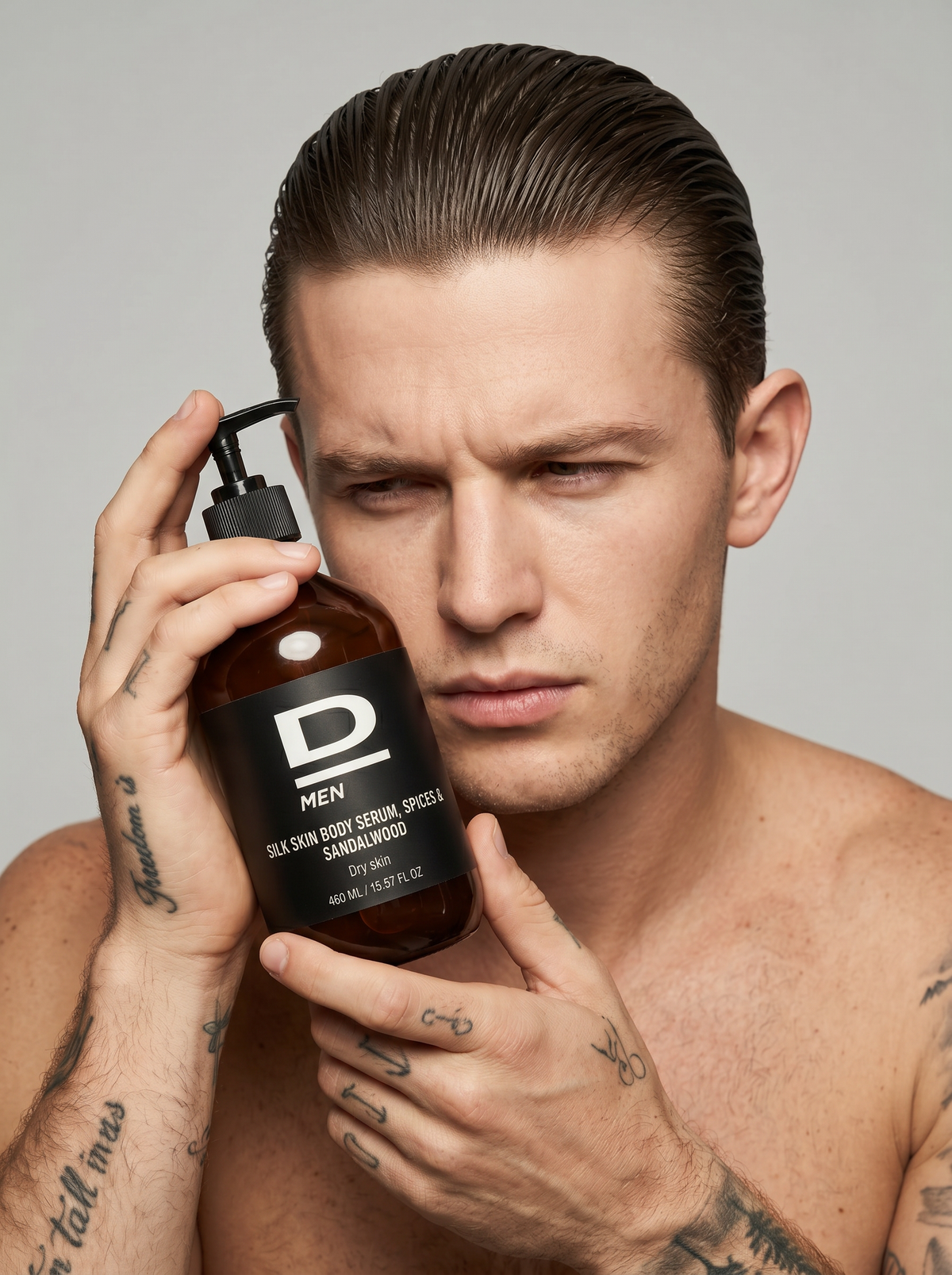 Mann mit zurückgekämmtem Haar hält eine braune Flasche mit schwarzem Pumpverschluss und weißer Aufschrift nah an sein Gesicht